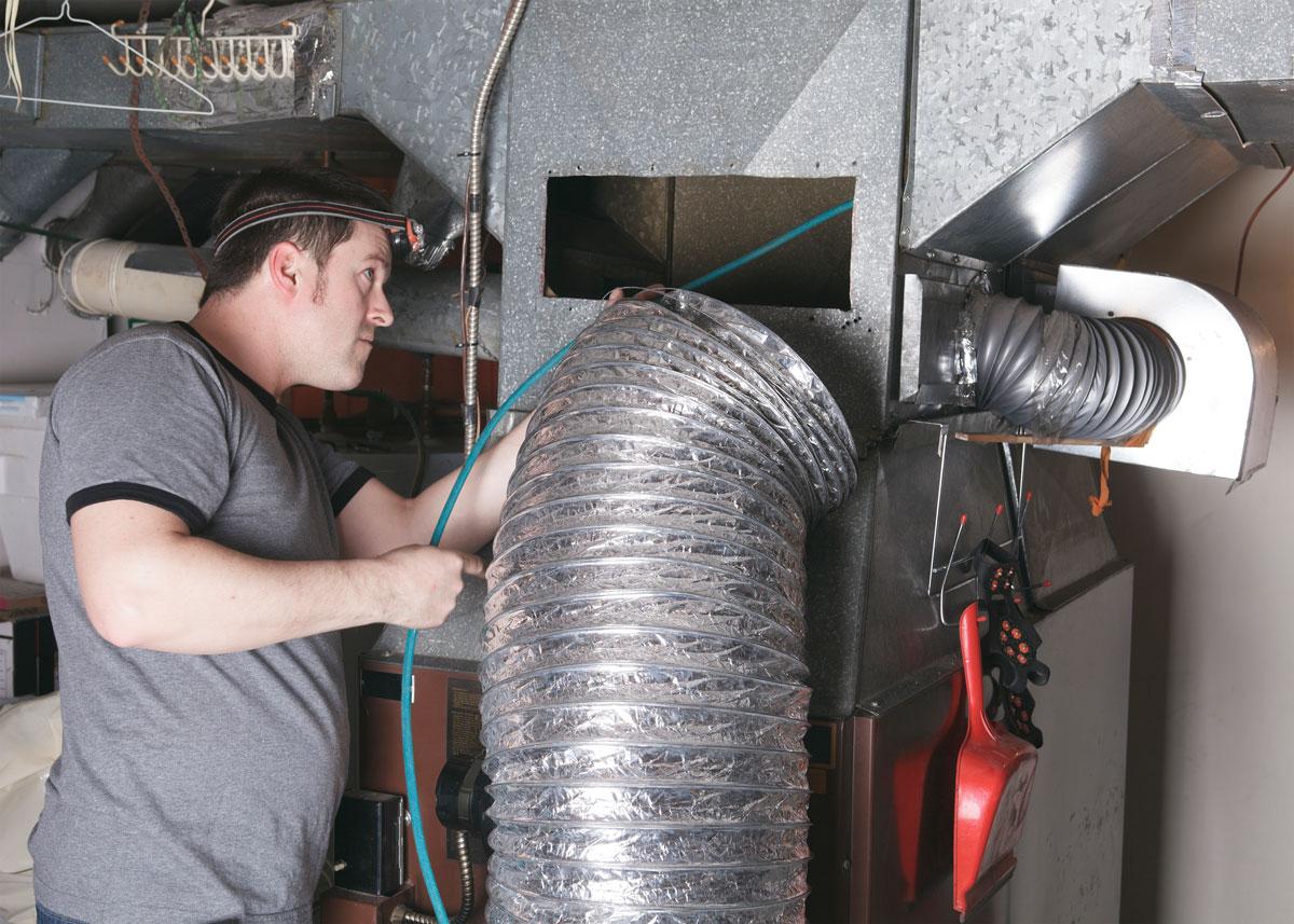 technician inspecting HVAC system before Air Duct Mold Remediation in Jackson, MS